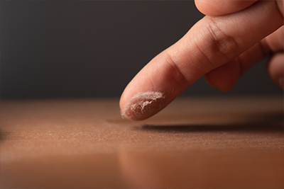 Finger swiping dust on table