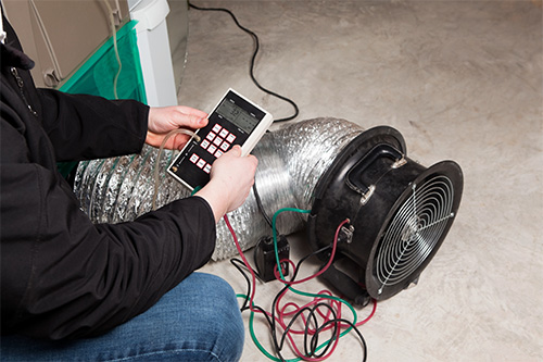 worker installing a whole house fan